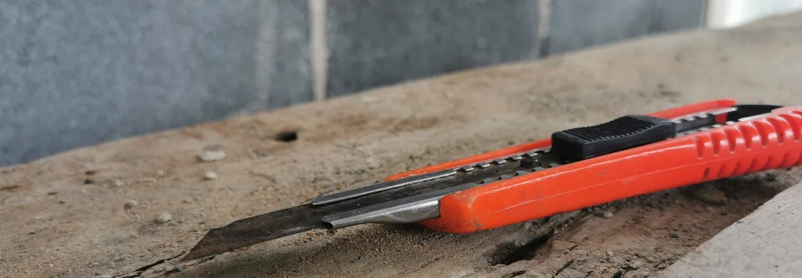 Teppichmesser auf Holzbrett